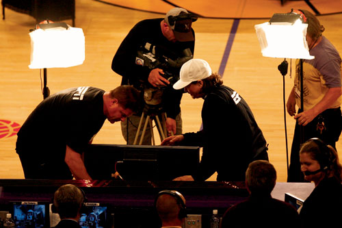 WARM-UPS - 3: Operators test a handheld camera before the game.